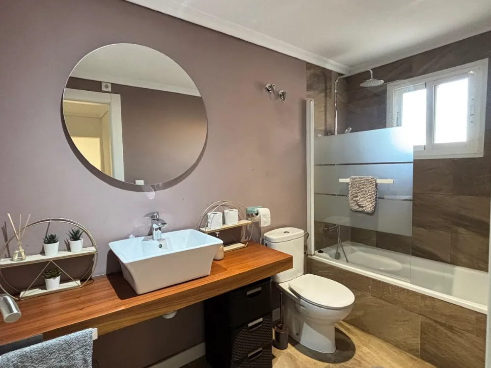 Salle de bain aux tons prune, douche et vasque, location vacances Costa Blanca